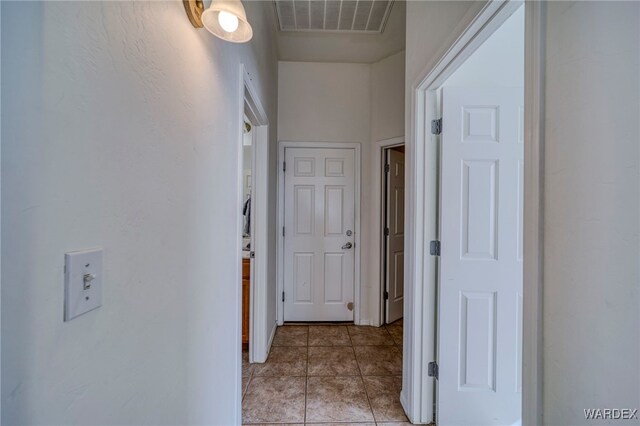 corridor featuring light tile patterned floors and visible vents