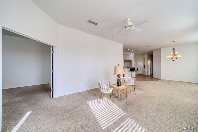 living area with light carpet, ceiling fan with notable chandelier, visible vents, and baseboards