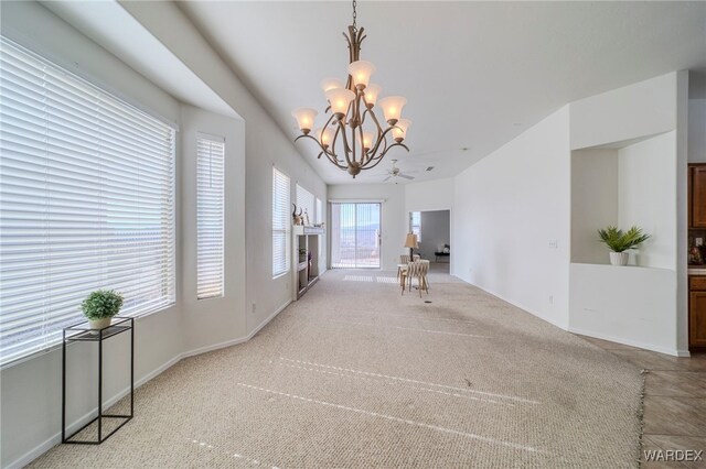 carpeted empty room with a chandelier and baseboards