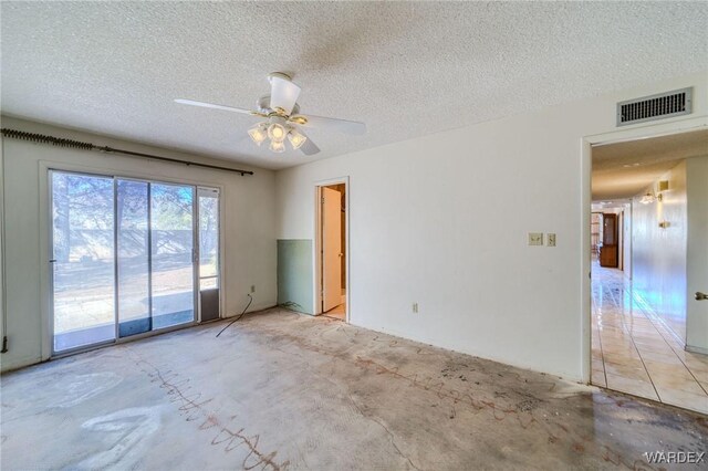 spare room with visible vents, ceiling fan, and a textured ceiling