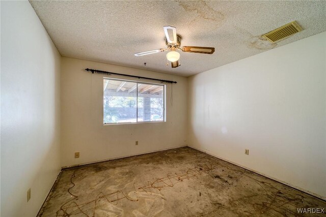 empty room featuring visible vents, ceiling fan, and a textured ceiling