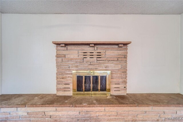 details featuring a textured ceiling and a stone fireplace