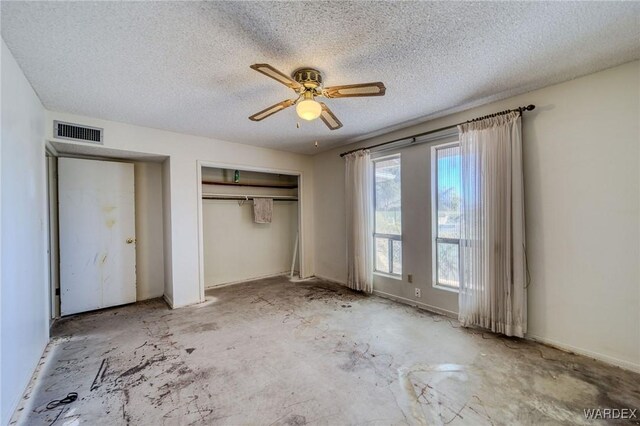 unfurnished bedroom featuring a closet, visible vents, ceiling fan, a textured ceiling, and baseboards