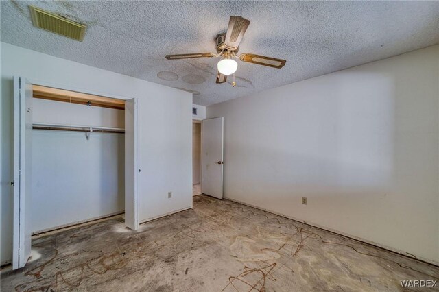 unfurnished bedroom featuring a closet, visible vents, ceiling fan, and a textured ceiling