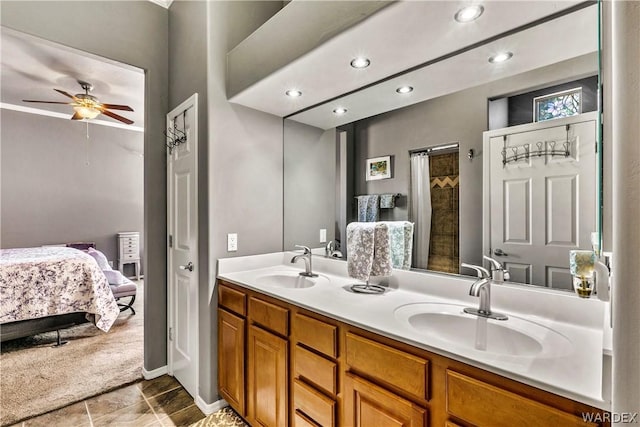 ensuite bathroom featuring a ceiling fan, connected bathroom, a sink, and double vanity