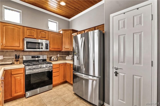 kitchen featuring stainless steel appliances, brown cabinetry, ornamental molding, and decorative backsplash