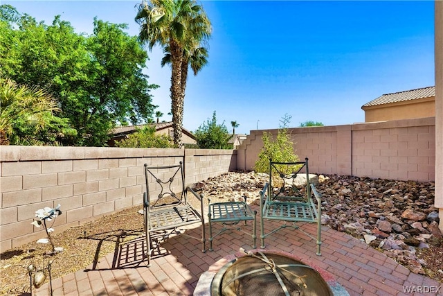 view of patio with an outdoor fire pit and a fenced backyard