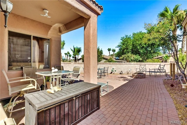 view of patio / terrace featuring a fenced backyard, a fire pit, and outdoor dining space