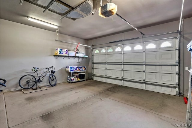 garage featuring a garage door opener and baseboards