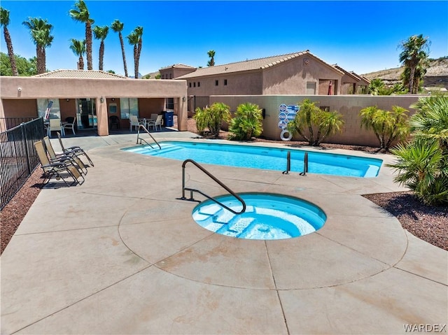 pool featuring a patio area, fence, and a hot tub