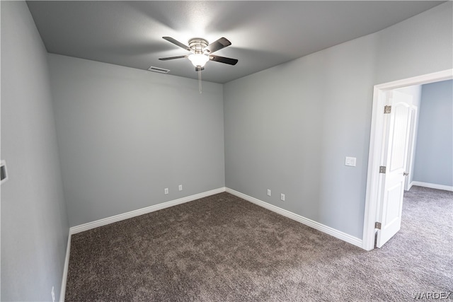 spare room with carpet floors, visible vents, and baseboards