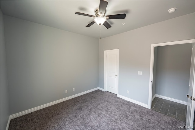 unfurnished bedroom featuring ceiling fan, dark carpet, and baseboards