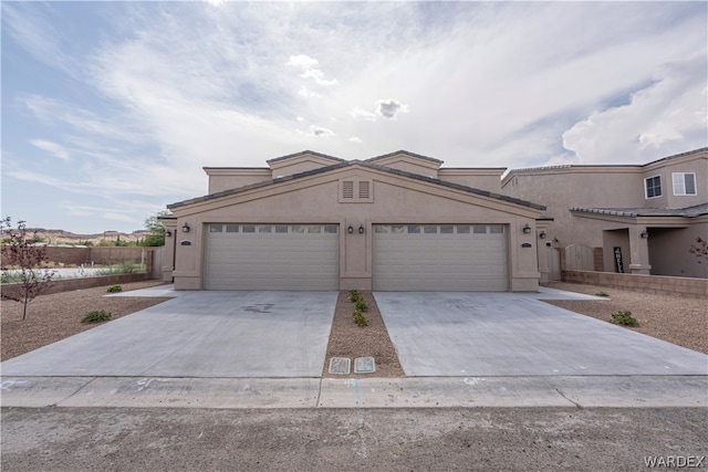 view of front of house with driveway, an attached garage, and stucco siding