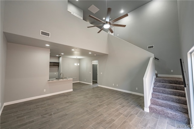 unfurnished living room with stairway, wood finished floors, and visible vents