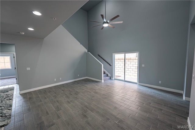 unfurnished living room with recessed lighting, dark wood-type flooring, a ceiling fan, baseboards, and stairway