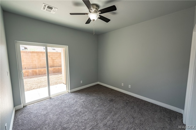 spare room featuring visible vents, dark carpet, baseboards, and ceiling fan