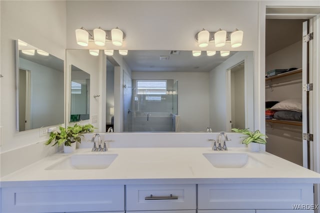 bathroom featuring a stall shower, a sink, and double vanity