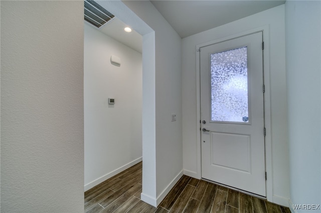 doorway to outside with wood tiled floor, visible vents, and baseboards