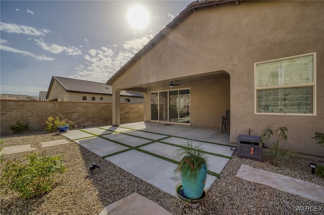 rear view of property featuring a patio area, fence, a ceiling fan, and stucco siding