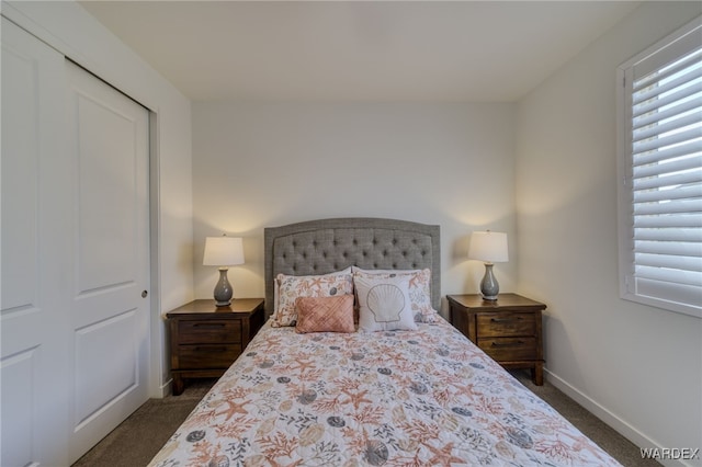 carpeted bedroom with a closet and baseboards