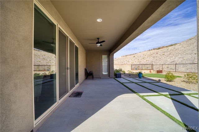 view of patio featuring ceiling fan and fence