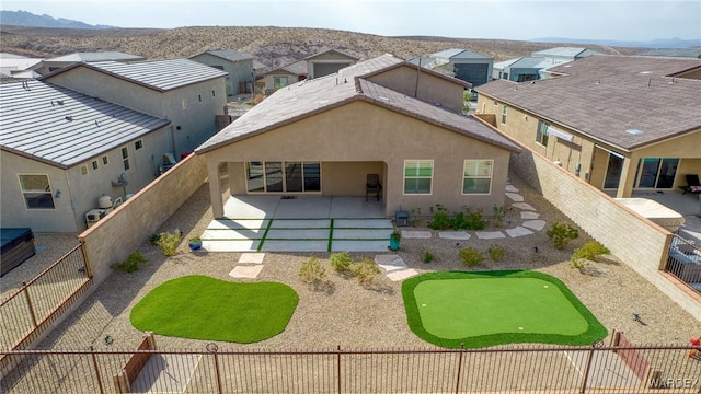 rear view of property with a fenced backyard, a residential view, a patio area, a mountain view, and stucco siding