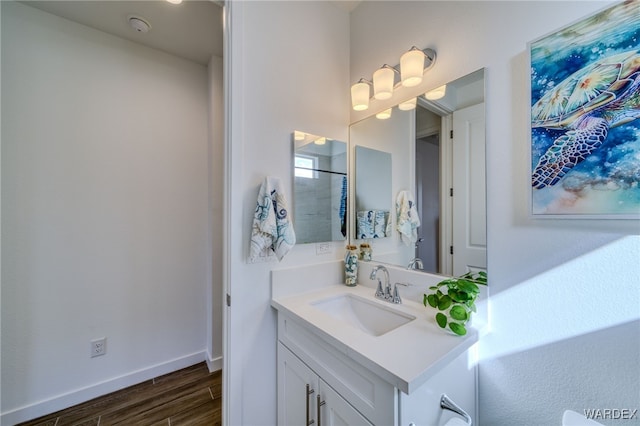 bathroom featuring wood finished floors, vanity, and baseboards