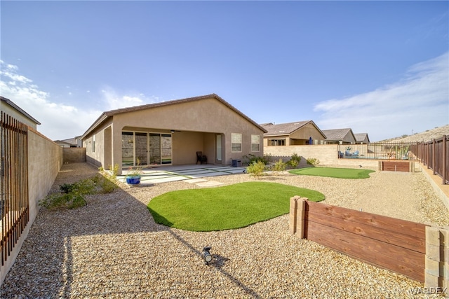 rear view of property with a patio area, a fenced backyard, and stucco siding