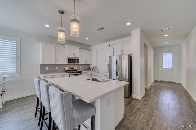 kitchen featuring visible vents, appliances with stainless steel finishes, backsplash, and a sink