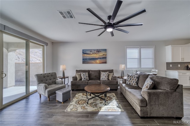 living room with wood tiled floor, visible vents, and a ceiling fan