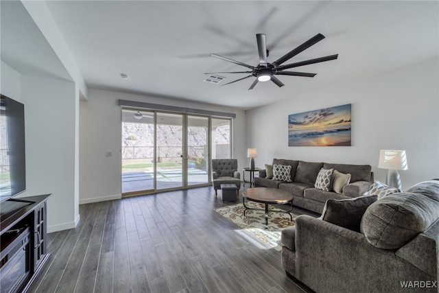 living room with dark wood-style floors, ceiling fan, visible vents, and baseboards