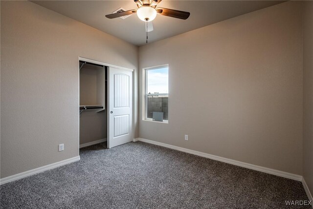 unfurnished bedroom featuring carpet floors, a closet, baseboards, and a ceiling fan