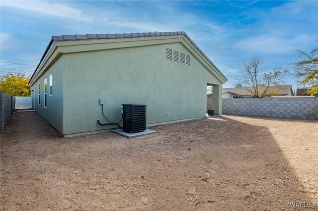 view of home's exterior featuring cooling unit, fence, and stucco siding