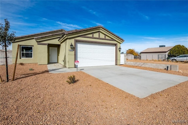 ranch-style home featuring an attached garage, concrete driveway, and stucco siding