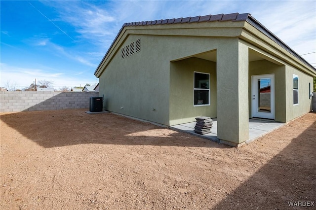 back of house featuring a patio, fence, cooling unit, and stucco siding