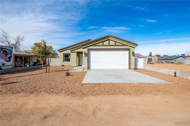 ranch-style house featuring stucco siding, driveway, an attached garage, and fence