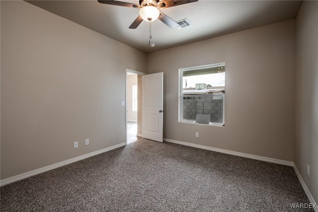 unfurnished room featuring carpet floors, visible vents, ceiling fan, and baseboards