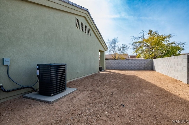 view of yard with central AC unit and a fenced backyard