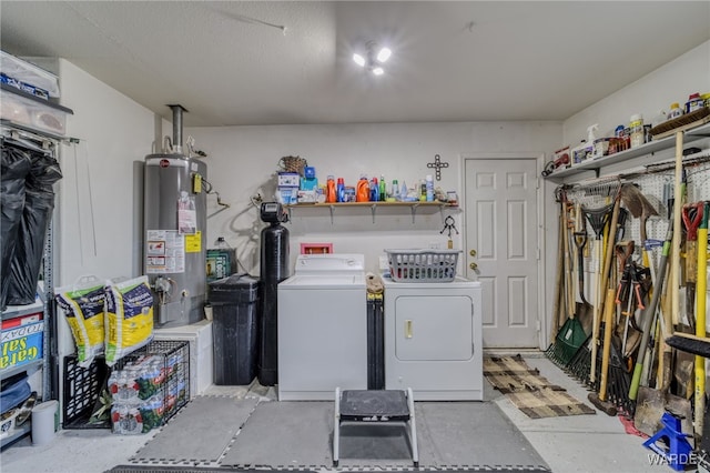 clothes washing area with laundry area, water heater, and separate washer and dryer