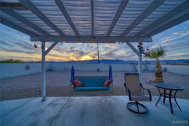 view of patio featuring a fenced backyard, a mountain view, and a pergola