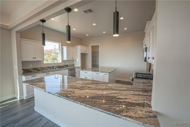 kitchen with stainless steel dishwasher, dark stone countertops, and white cabinets