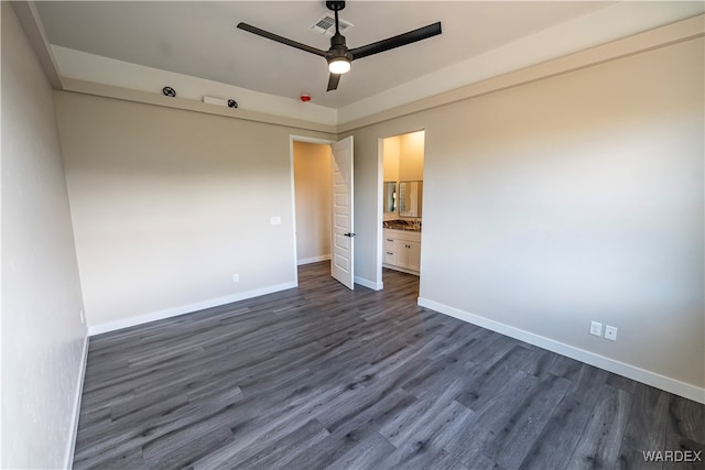 unfurnished bedroom with ceiling fan, dark wood-style flooring, visible vents, baseboards, and ensuite bath