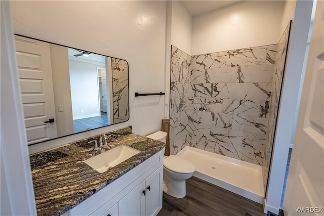 full bath with toilet, a shower stall, wood finished floors, and vanity