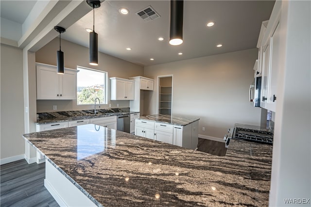 kitchen with visible vents, white cabinetry, pendant lighting, and dark stone countertops