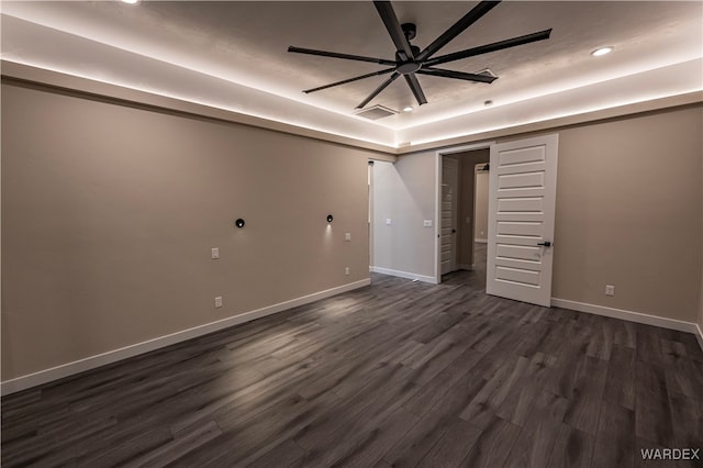 unfurnished bedroom with visible vents, baseboards, a raised ceiling, dark wood-type flooring, and recessed lighting