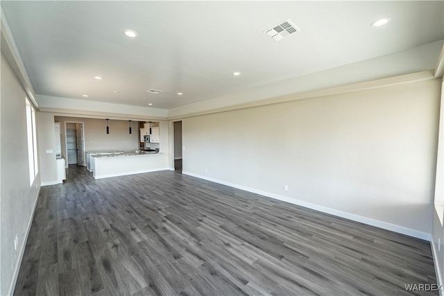 unfurnished living room featuring baseboards, visible vents, dark wood-type flooring, and recessed lighting