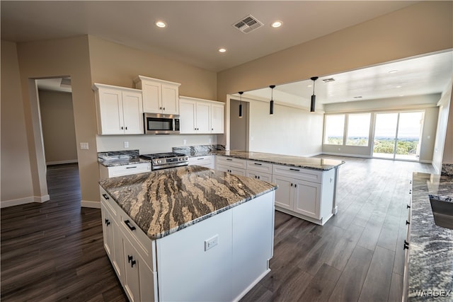 kitchen featuring hanging light fixtures, appliances with stainless steel finishes, visible vents, and white cabinets