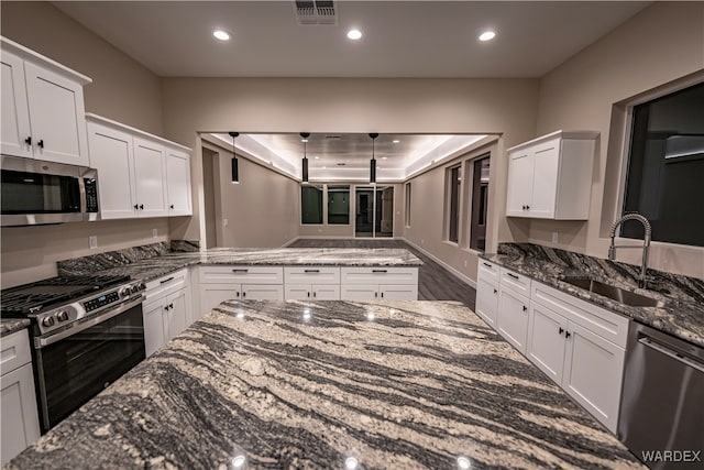 kitchen featuring stainless steel appliances, white cabinetry, and a sink