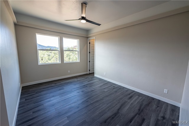 spare room featuring ceiling fan, dark wood-type flooring, and baseboards