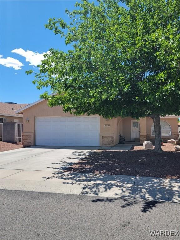view of front of house with stucco siding, an attached garage, and driveway